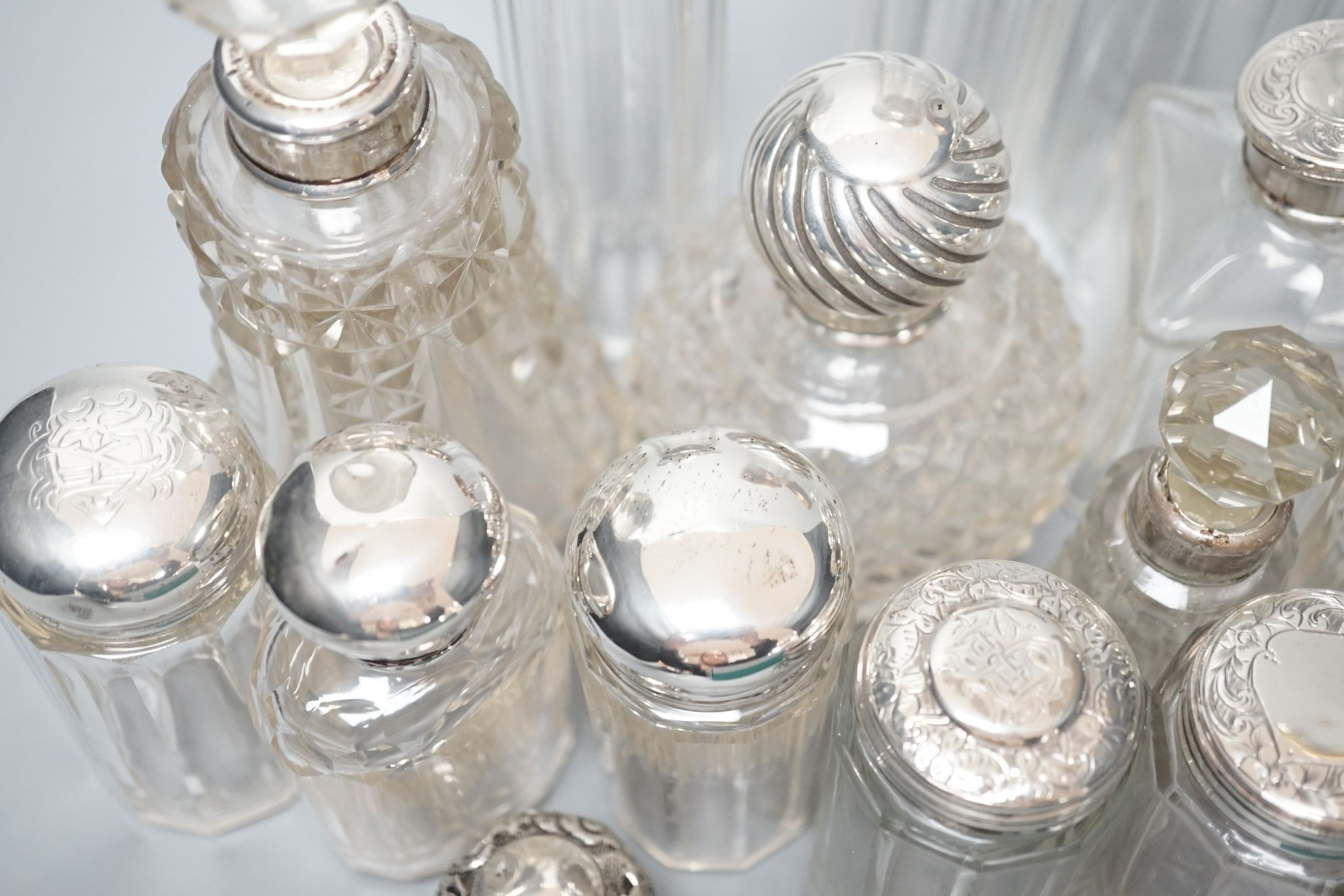 A collection of assorted mainly silver-capped scent bottles and toilet bottles.